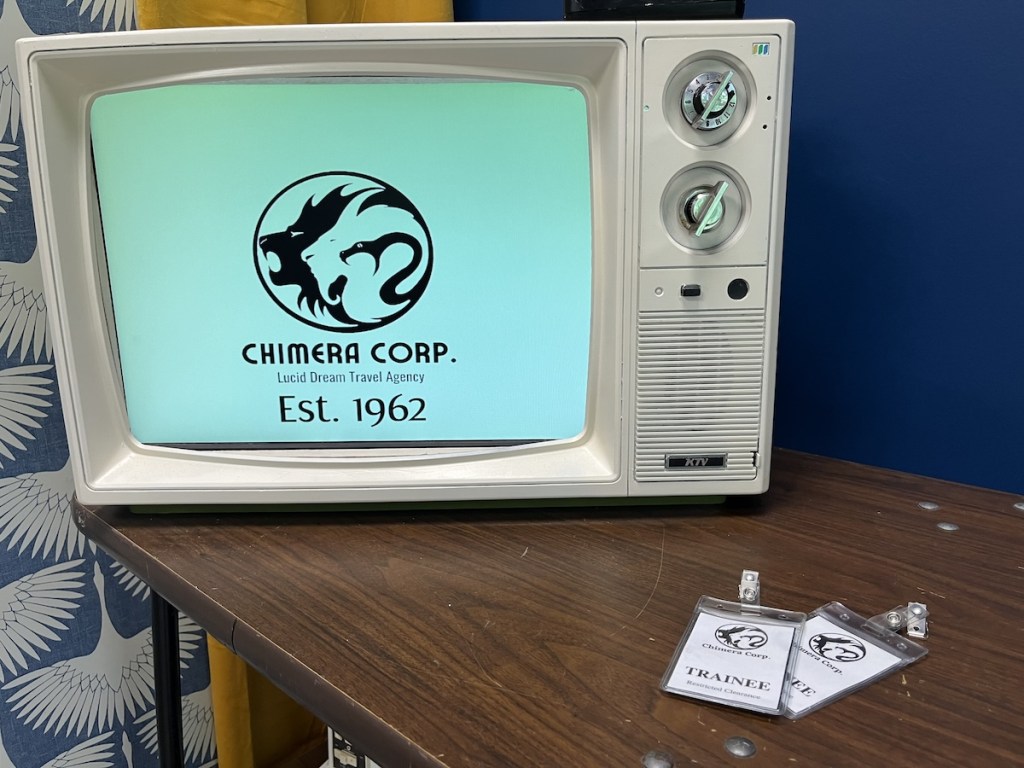 An old television with the screen showing the logo for "Chimera Corp. Lucid Dream Travel Agency, est 1962."