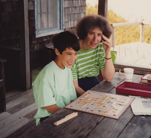 child playing scrabble with his mother on a picnic table