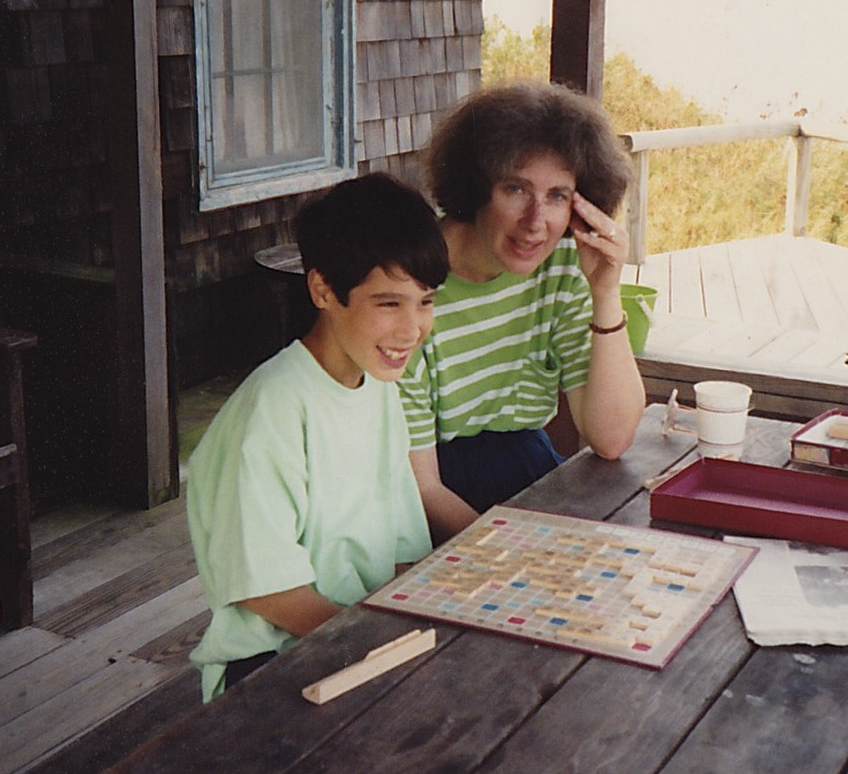 child playing scrabble with his mother on a picnic table