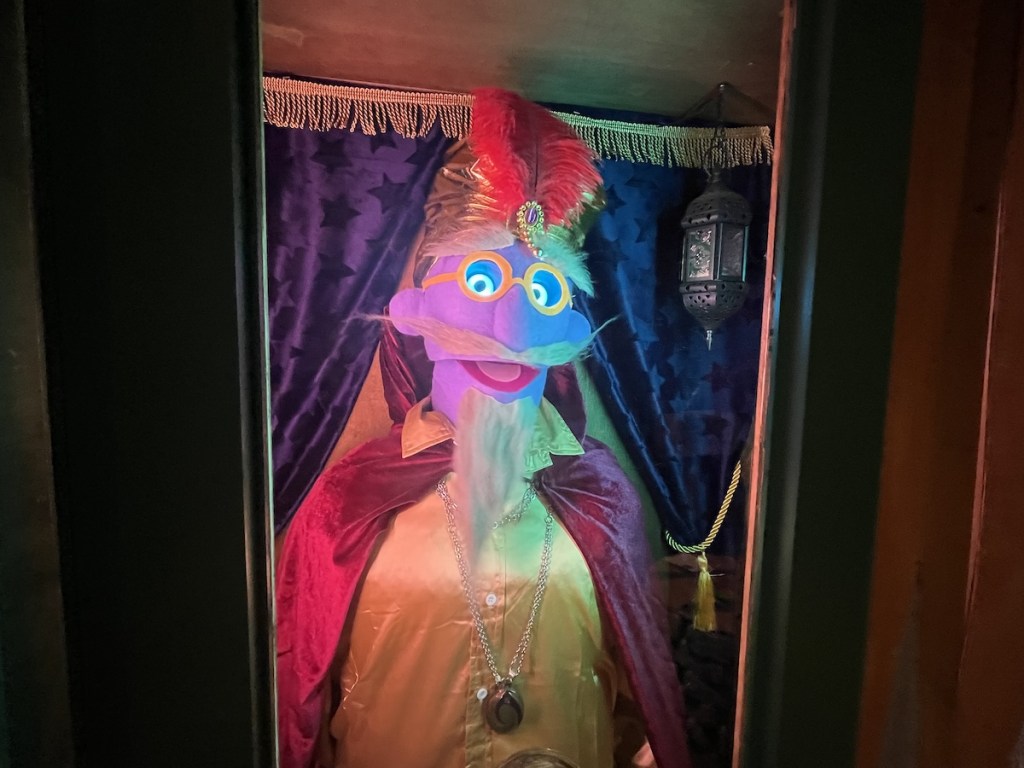A muppet-like creature dressed as a fortune teller.