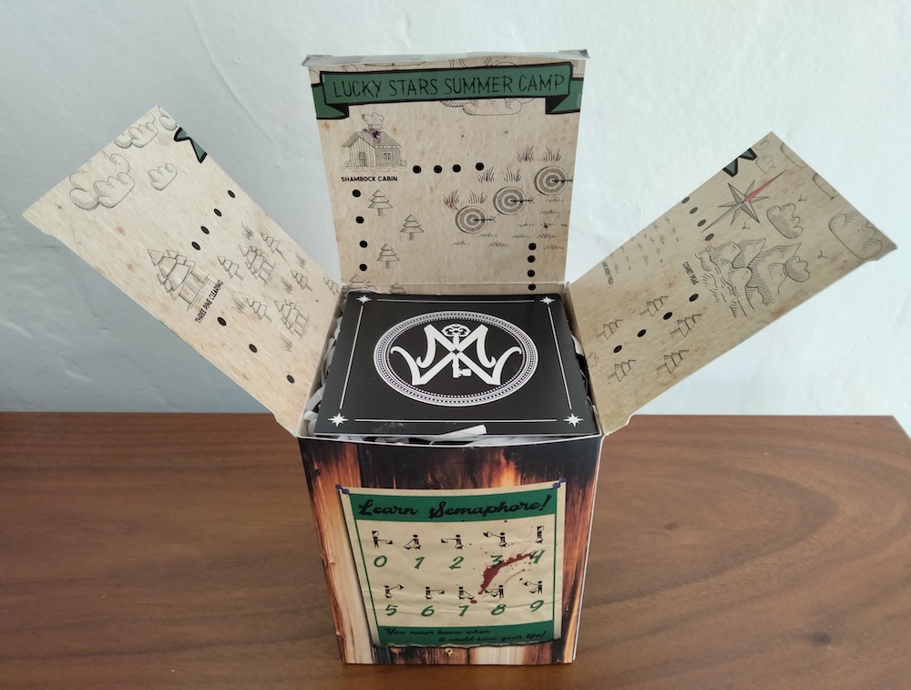 An open box with a "Learn Semaphore" note on the front and a partial map of Lucky Stars Summer Camp on the inside flaps.