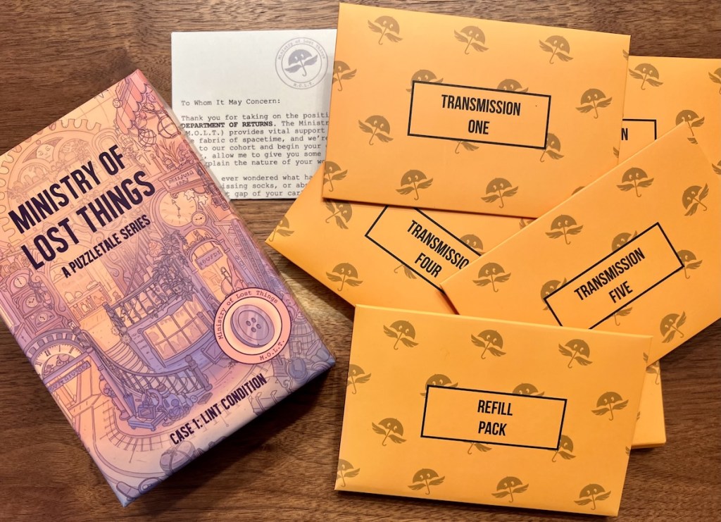 Ministry of Lost Things box beside an introductory letter and an assortment of orange Transmission envelopes.