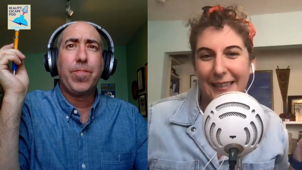 on left is a man wearing a denim button down shirt and headphones holding a pen. on the right is a woman with brown curly hair pulled up with a bandana. She has a microphone and earpods on, and is wearing a light blue denim shirt