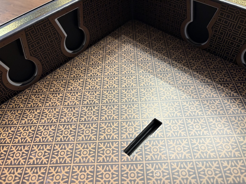 Interior of the upper box, with an intricate black and gold pattern.