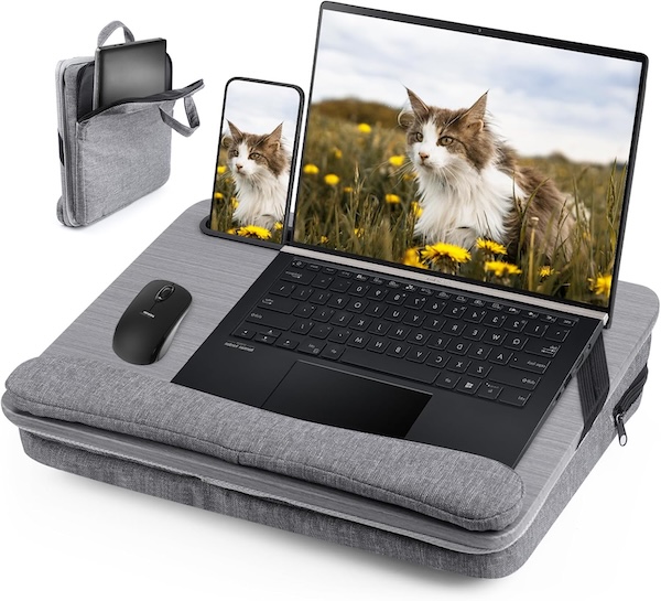 A lapdesk with a computer, phone, and mouse. The screen has a cat on it.