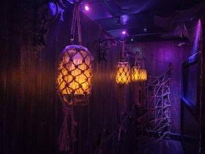A hallway with rope lanterns hanging from metal hooks.