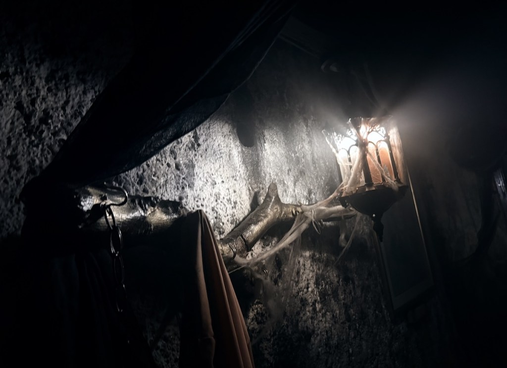 A lantern glowing in a dark, dingy room.