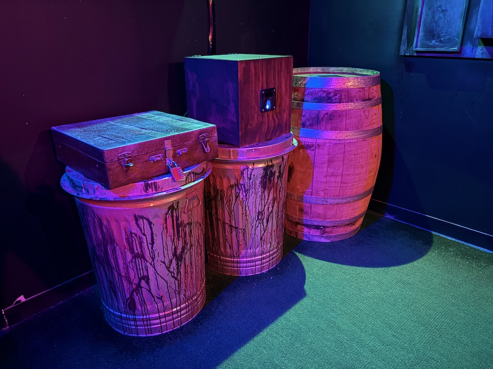Locked boxes atop crates and barrels.