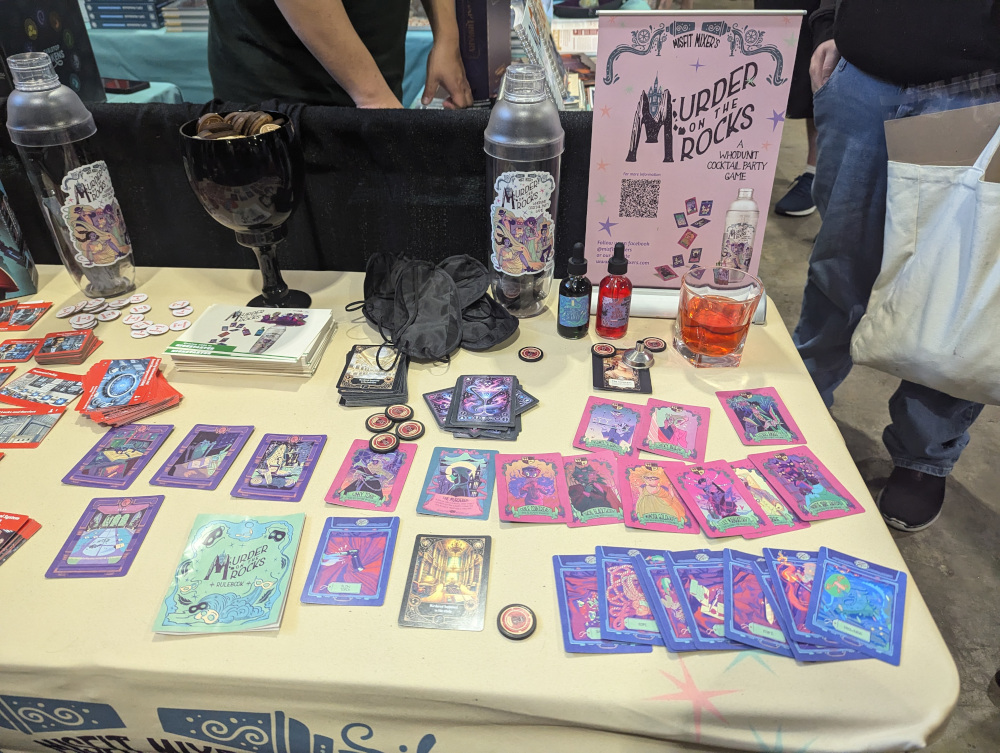 A display of the murder mystery game Murder on the Rocks, The game uses colorful cards and two vials of colored liquid.