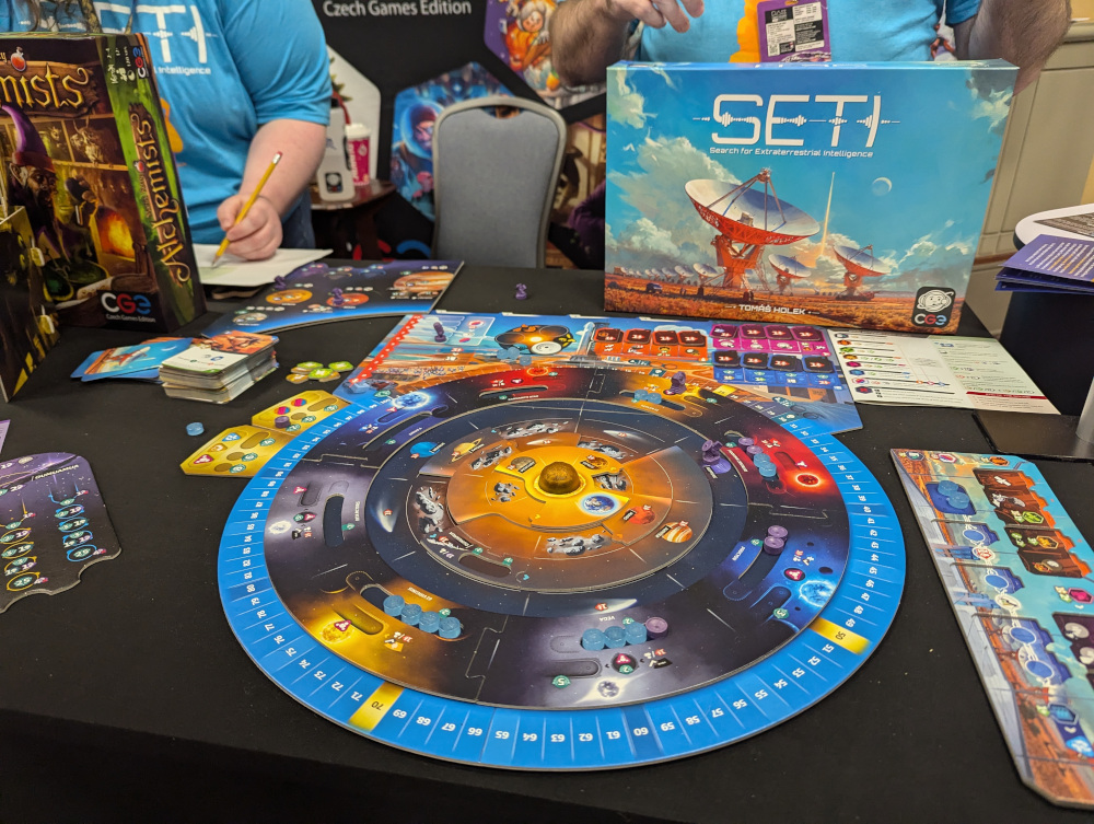 A display of the board game SETI, showcasing the planetary board, a player board, and the technology board.
