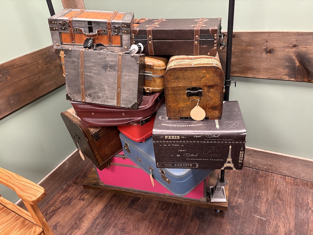 A pile of luggage on a baggage cart.