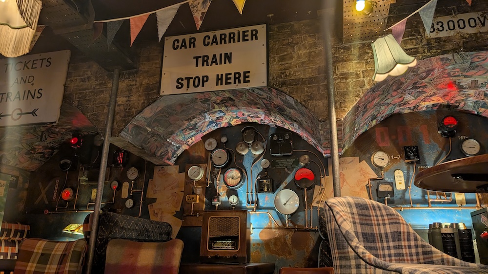 Stone archways in a train station, pipes and gauges are all over the walls.
