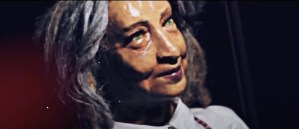 Wax sculpture of an older woman with green eyes and gray hair.