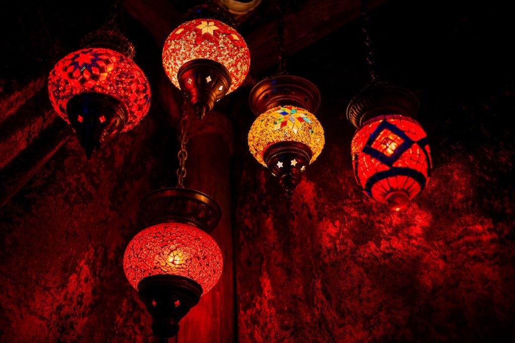 An assortment of colorful glass lamps illuminated in a dim room.
