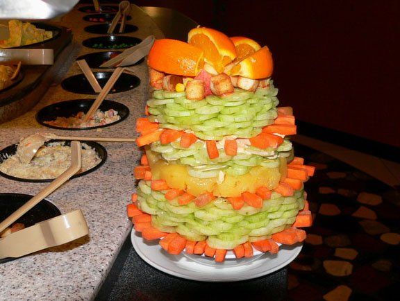salad tower built from cucmber, carrot sticks, pineapple and oranges