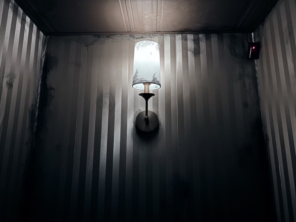 A sconce hung on an old wall.