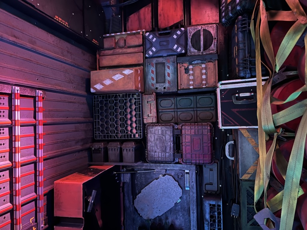 A large stack of boxes and crates secured in a cargo hold on a spaceship.