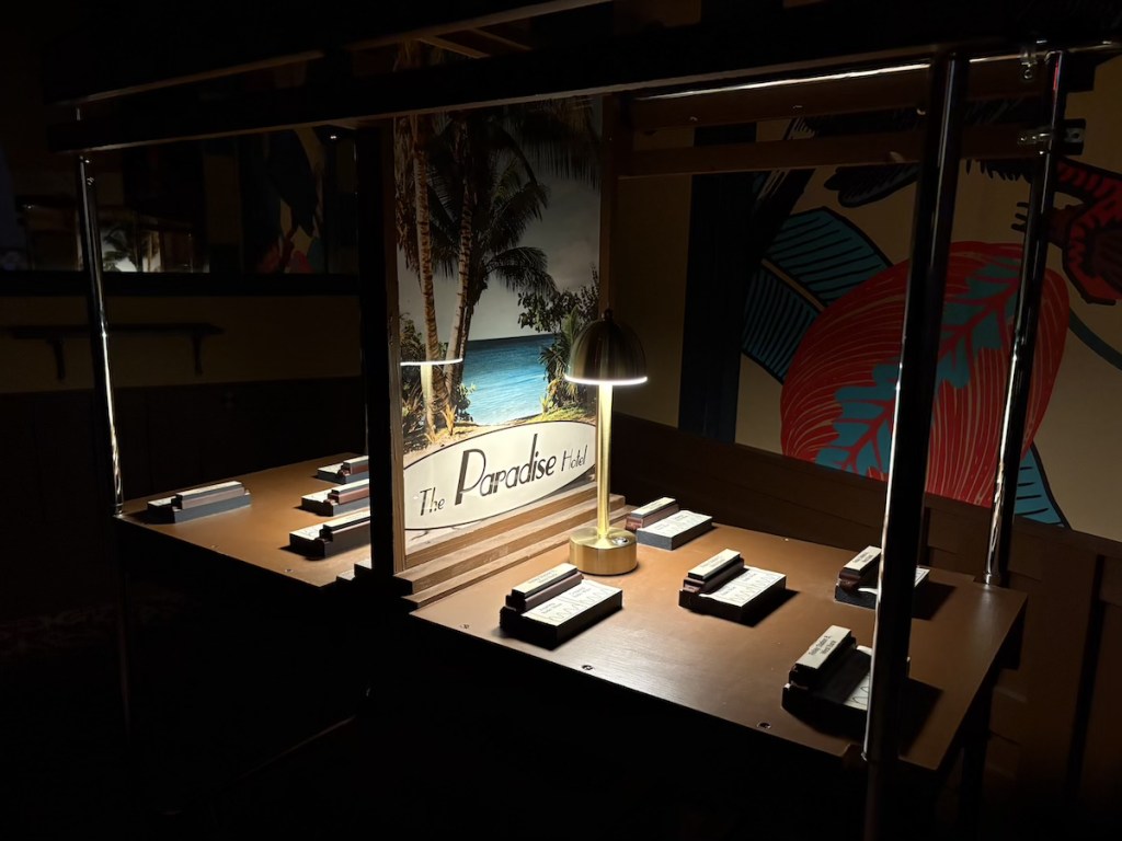 A dimly lit table labeled "The Paradise Hotel."