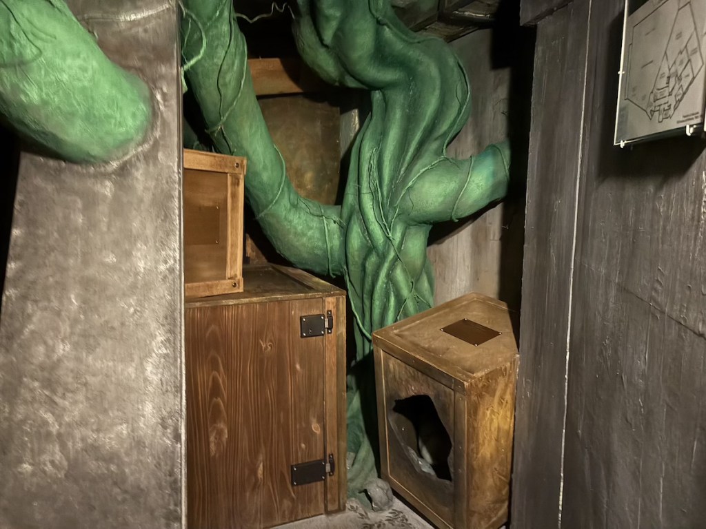 A room filled with crates and a very large beanstalk