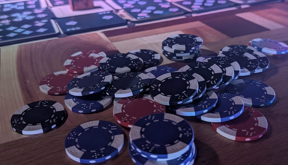 A pile of poker chips on a wooden bar.