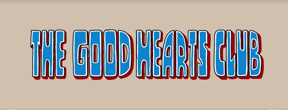 A screenshot of the title screen from the movie "The Good Hearts Club" simply shows the title in blue block letters set against a beige background.