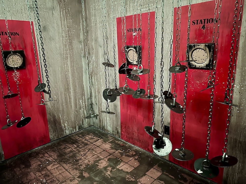 chains with metal disks hanging in front of 4 red stations.