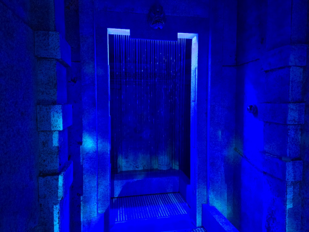 A curtain of water showering down through a doorway in an ancient undersea temple.