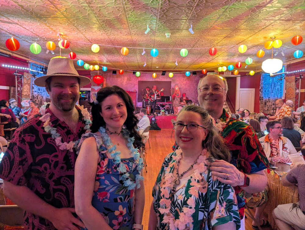 Photo of Andrew, Madeleine, Denise, and Brett dressed up in the decorated game space.