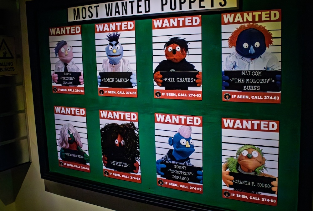 A wall of wanted posters for puppets that had committed various heinous crimes.