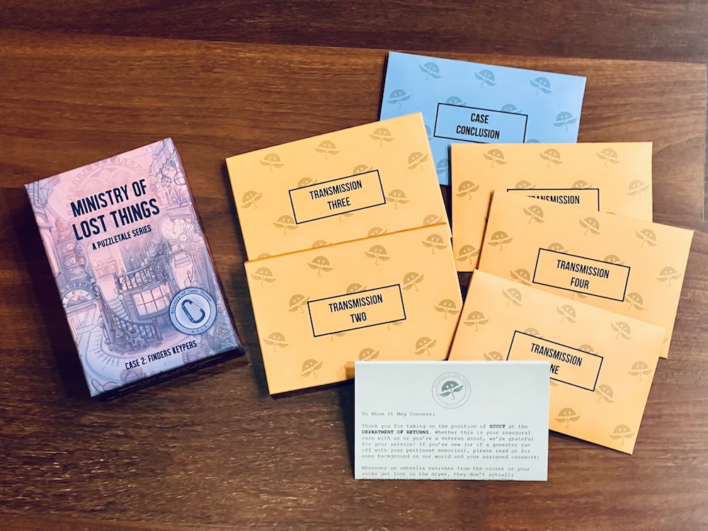 Purple, intericately illustrated box for Ministry of Lost Things, A Puzzletale Series, Case 2: Finders Keypers. The box is be 6 envelopes containing different transmissions.