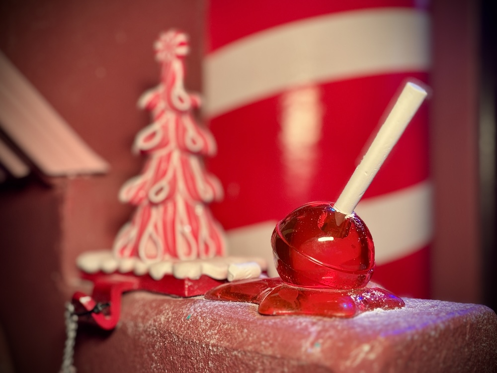 A melted red lollipop, amidst various other sweet decorations.