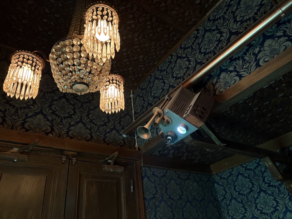 An ornate chandelier beside a strange steampunk projector.