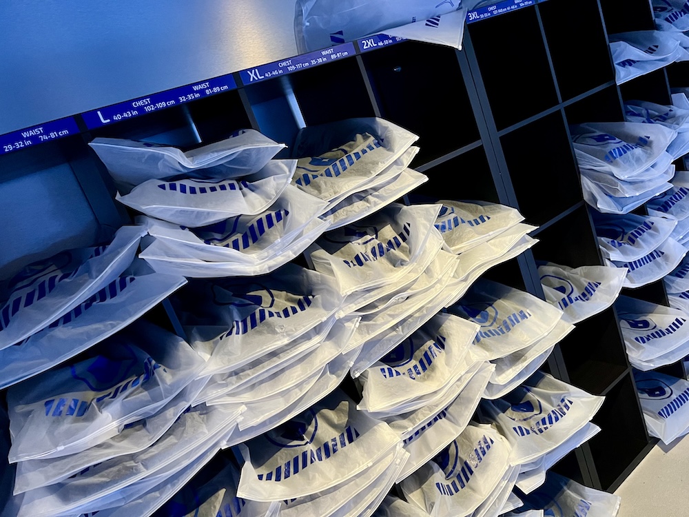 A matrix of cubbies filled with sealed bags of player costumes.