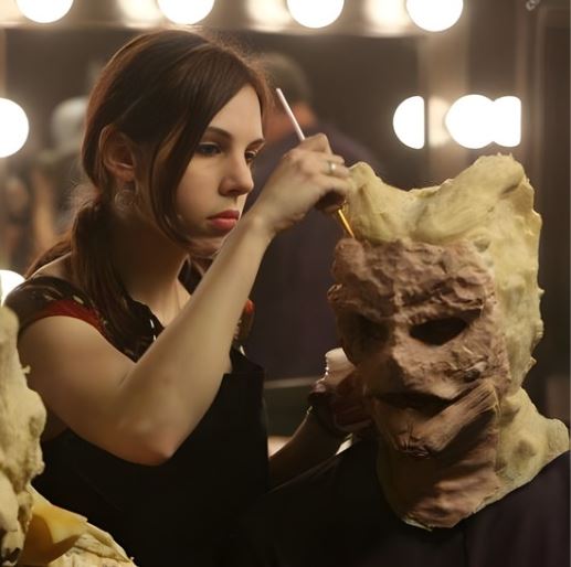 a brunette woman sculpting a monster mask