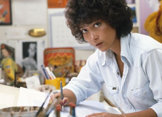 woman with short curly hair working at artist desk