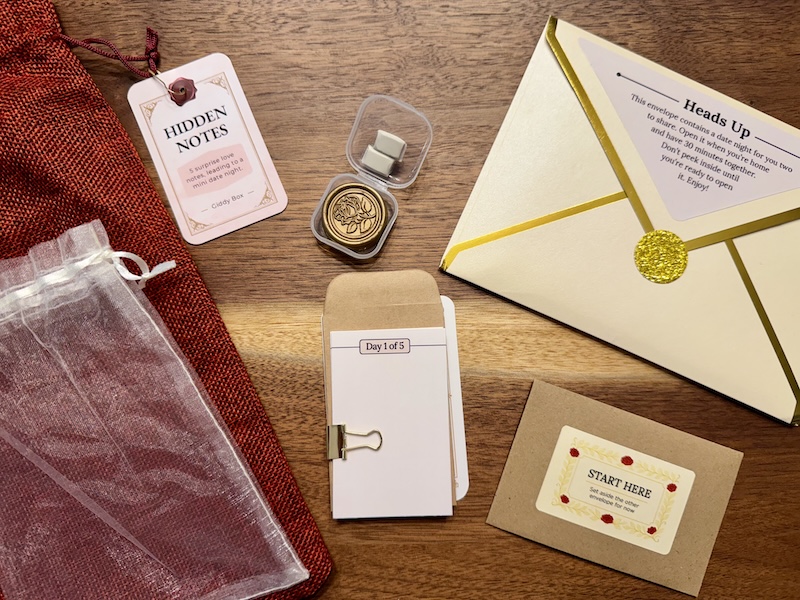 The contents of Hidden Notes laying on a tabletop. It contains an assortment of stationary.