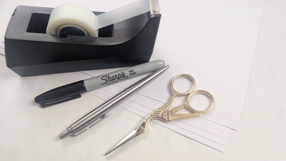 Stationary including a tape dispenser, a sharpie, a pen, and a beautiful pair of bird-shaped scissors.