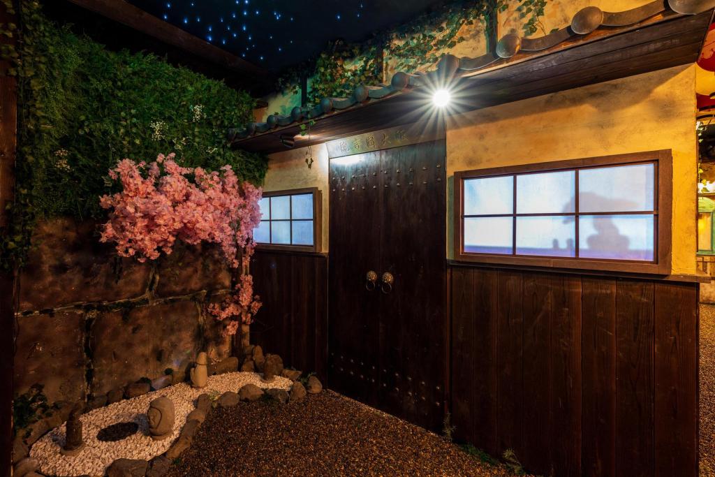 The front entrance to a Japanese temple, with a small rock garden in the front