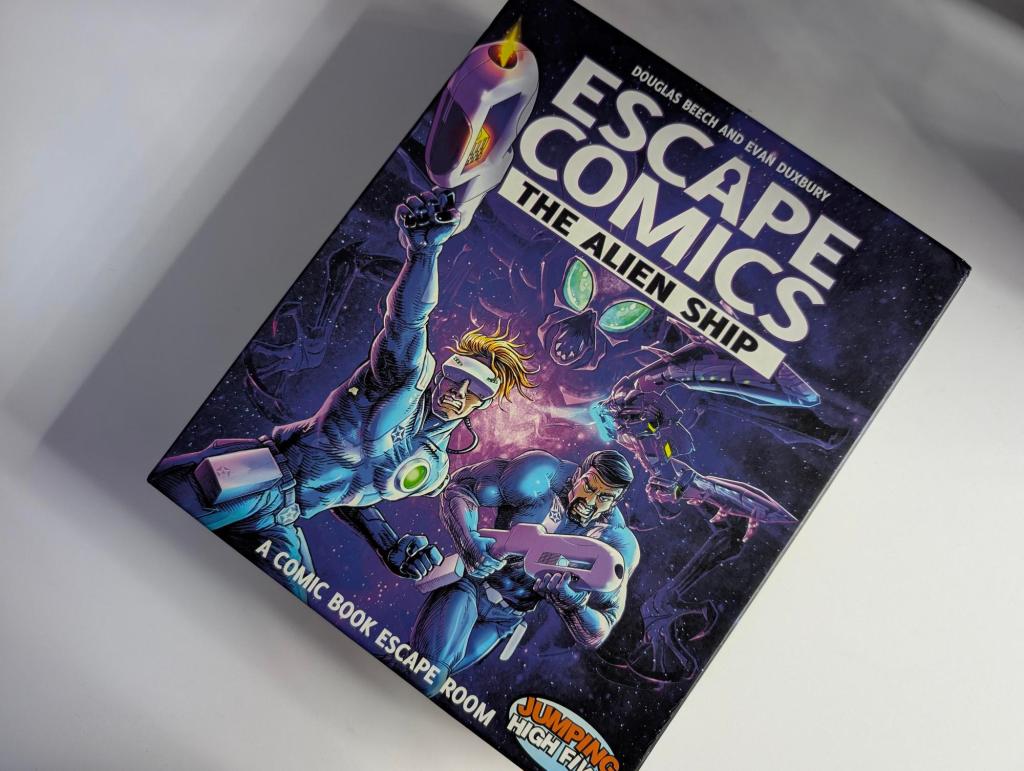 The Escape Comics: The Alien Ship box with two sci-fi space superheros and a large humanoid bug in the background.