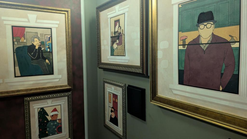 5 framed drawings are hung on a wall, each depicting a person in their homes, each missing facial features.