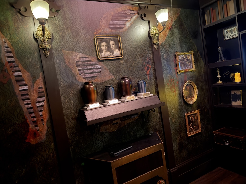 An old rundown wall in a haunted house. There are bloody handprints, and a shelf with 4 urns.