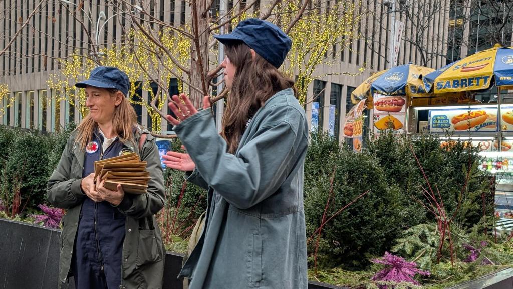 Two Great Gotham Challenge Cluemasters presenting in front of a hot dog stand