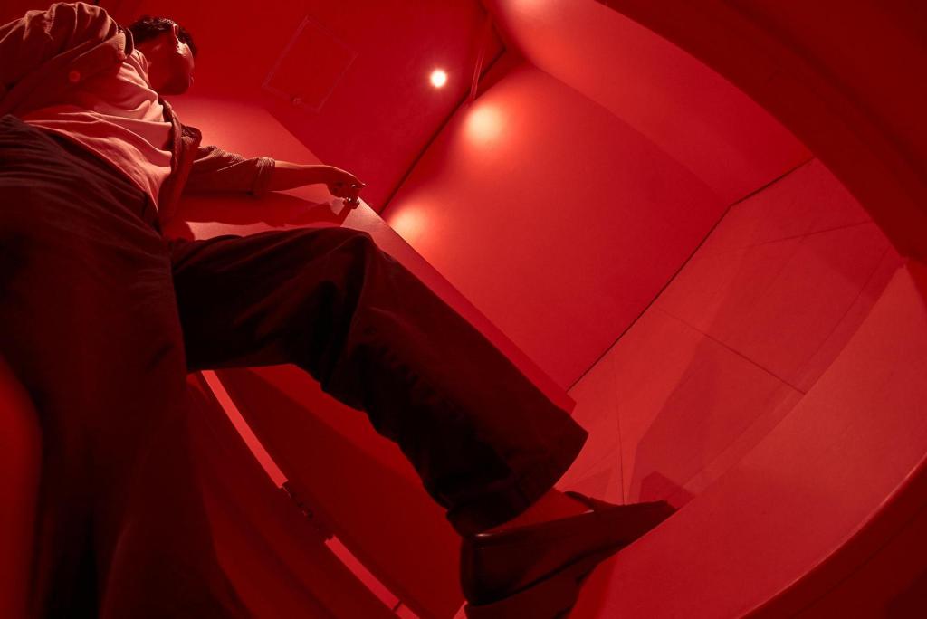 A person entering a seemingly empty red room