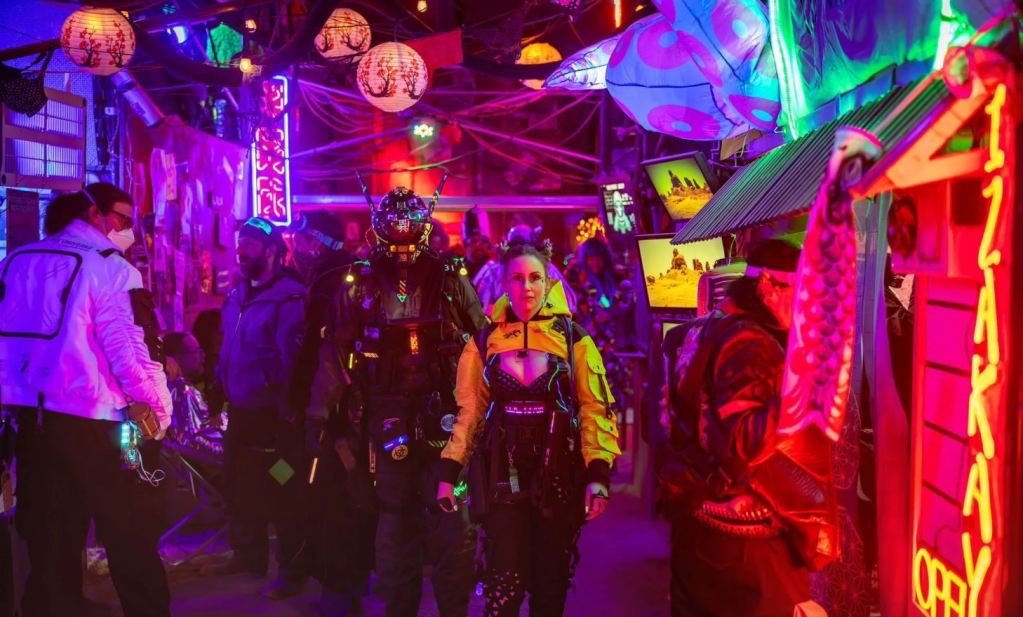 cyberpunk street filled with neon lights and people in cyberpunk costumes, including woman with yellow jacket with many pockets and tactical style gear