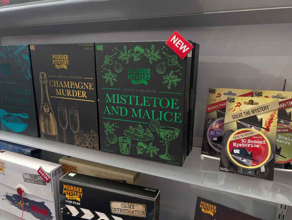 close up shot of a series of boxed murder mystery games, focused on one called Mistletoe and Malice