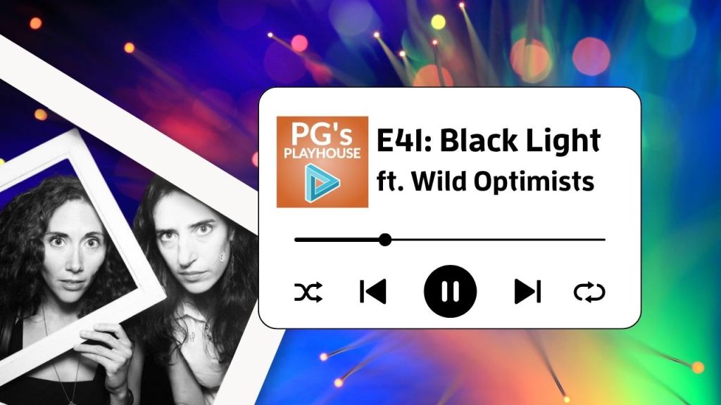 black and white image of two women holding white frames around their faces. both have large eyes, with dark curly hair. background is dark splash of colorful light.