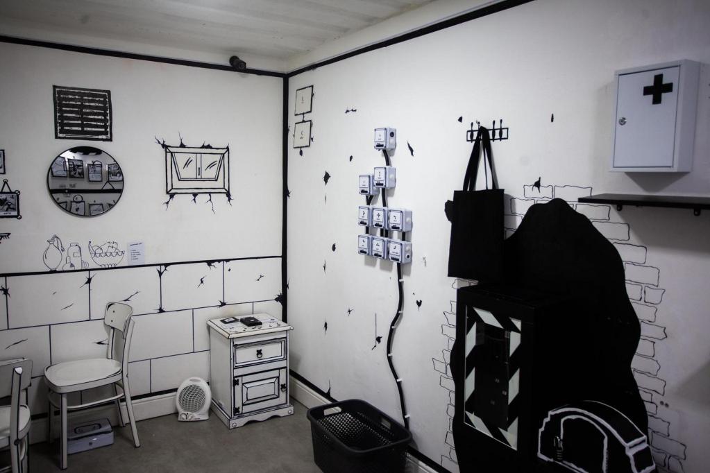 A black-and-white cartoon room with variou symbols and images covering the walls