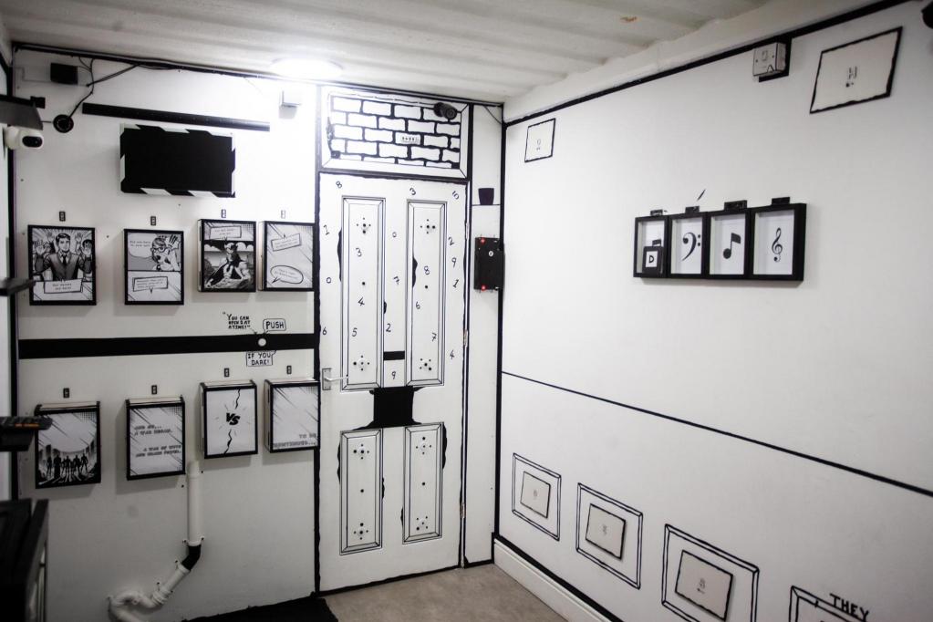 A black-and-white cartoon room with variou symbols and images covering the walls
