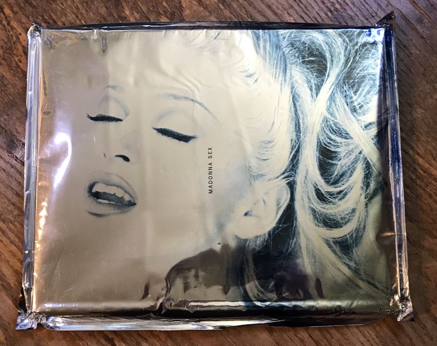 foil bag covering a book. image on bag is beautiful woman with eyes closed and wavy blonde hair. image reads "madonna sex"