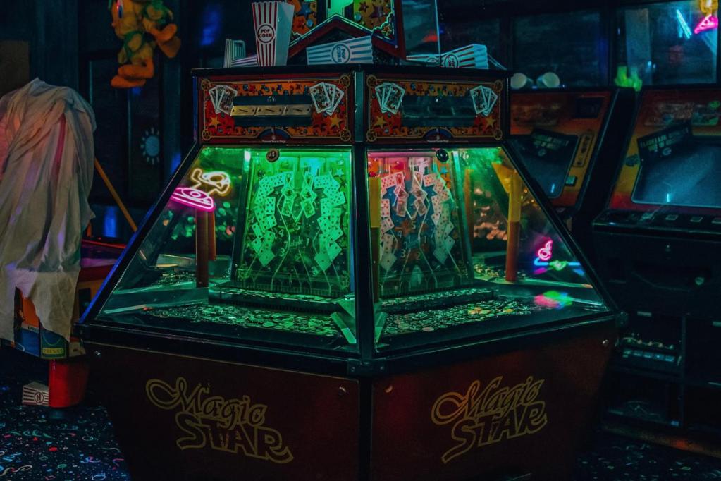 A coin pusher arcade machine labeled "Magic Star" in the center of a retro arcade